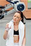 cute athletic woman drinking water after exercises in a fitness centre