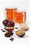 Plum tea with ginger, anise and clove on white background