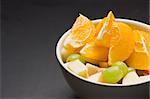 Big bowl of juicy fruit with oranges, apples, grapes