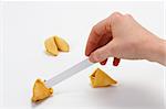Fortune cookie with hand pulling out fortune