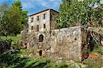 Vintage stone tank for grape stomping and derelict house ruins. Zakynthos, Greece.