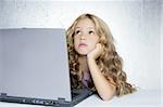 Student little school girl homework on laptop computer silver background