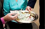 Church members putting money in the collection plate.