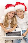 Searching for the perfect christmas gift online - kids with laptops and santa hats