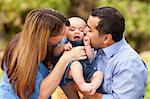 Happy Mixed Race Parents Playing with Their Giggling Son.