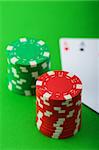 Casino-Chips und Karten vor grünem Hintergrund