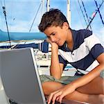 teenager on boat with laptop