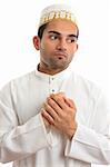 An ethnic man in traditional robe holding two hands to his chest and pondering.  White background.