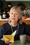 Senior woman at home reading sympathy card