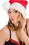 close up portrait of a young blond woman wearing a red christmas hat and making face