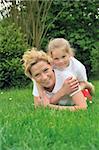 Young mother and daughter laying on the grass