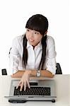 Young business woman working in office with laptop on desk.