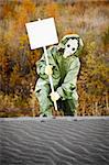 Scientist in protective suit and gas mask carry poster