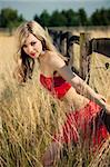 pretty girl in a red satin dress in a wheat field
