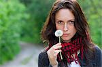 Girl holding in her hand a white dandelion