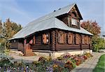 Beautiful brown wooden house with flower bed in Pokrovsky Monastery of Suzdal, Russia