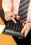 businessman counts money on calculator - close-up view