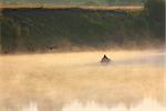 man fishing on morning river in fog