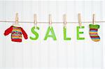 SALE on a Clothesline with Warm Winter Clothing.  Holiday Concept.