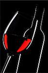 Red wine bottle and glass silhouette over black background