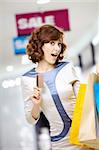 Attractive smiling curly woman on shopping with a credit card