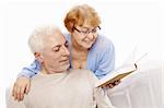 The elderly couple reads the book on a white background