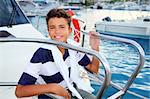 teenager boy sea marina summer vacation sitting in boat bow as sailor