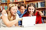 Kids in the school library, using the computer, are surprised by what they are learning.