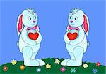 Toy rabbits with red valentines hearts in paws standing on a flower meadow