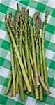 Fresh asparagus on a green checkered picnic blanket.  Healty summer eating.