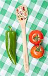 Legumes, tomatoes and a green pepper on a bright green checkered picnic blanket. Healthy Summertime Eating.