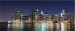 New York City Manhattan skyline panorama with office skyscrapers building illuminated with lights at night