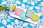 Sale Tag on a Winter Holiday Snowflake Background.