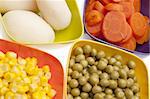 Vibrant Canned Vegetables Isolated on White close up.  Carrots, Corn, White Potatoes, and Peas.