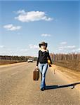 country girl with guitar goes on road solitary under sky