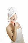 Young beautiful woman with healthy strong teeth and white towel on her head holding tooth brush in bathroom