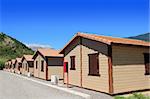 Wooden bungalow houses in camping area in Pyrenees mountains