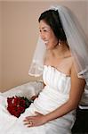 Beautiful bride wearing a traditional gown with red roses