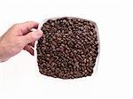 hand that hold a dish full of coffee beans