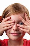 Little girl peeping through hand with one eye isolated over white background