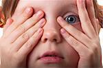 Little girl peeping through hand with one eye macro shot