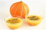 Two bowls of pumpkin soup and pumpkin in Thanksgiving Day or Halloween