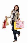 Happy shopping woman holding bags isolated over white.