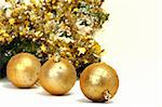 Gold Christmas balls on a background decorated with fir branches.