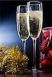 Two full glasses of champagne over gray background