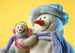 Snowman with his little baby on yellow background