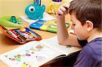 boy doing homework  with color pencil, painting fruits