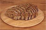 Soda bread loaf in slices on a carved wooden beech bread board over oak wood.