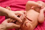 Mum massaging her baby's foot shallow focus