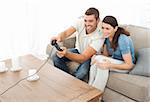 Attentive couple playing video game together in the living room at home